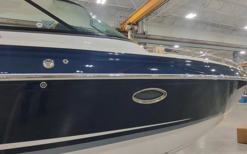 Slide: The Image of 2025 Formula 310 Bowrider OB boat in a showroom, showcasing sleek blue and white design. - 12