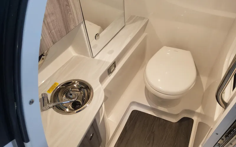 Slide: The Image of 2025 Formula 310 Bowrider OB bathroom with sink, toilet, and wood accents. - 28
