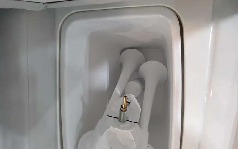 Slide: The Image of 2025 Formula 310 Bowrider OB boat horn detail in white compartment. - 48