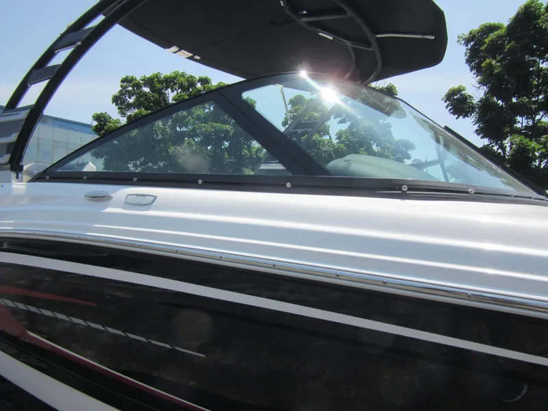 Slide: The Image of 2025 Chaparral 23 SSi boat with sleek design and tinted windshield under sunlight. - 10