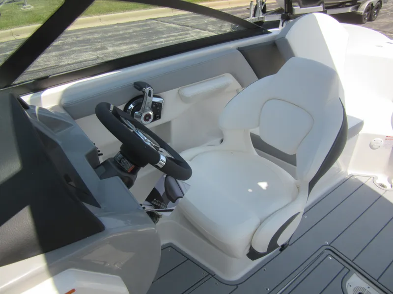 Slide: The Image of 2025 Chaparral 23 SSi boat interior with white captain's seat and steering wheel. - 18