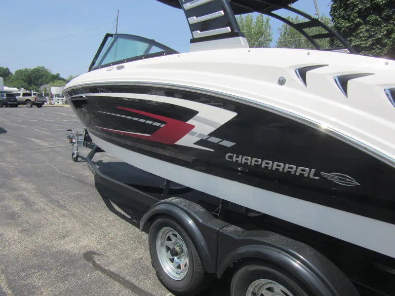 Slide: The Image of 2025 Chaparral 23 SSi boat on trailer, sleek design with black and red accents. - 2