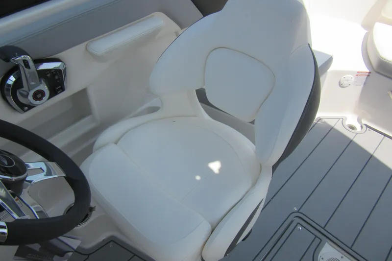 Slide: The Image of 2025 Chaparral 23 SSi boat cockpit with white captain's chair and steering wheel. - 25