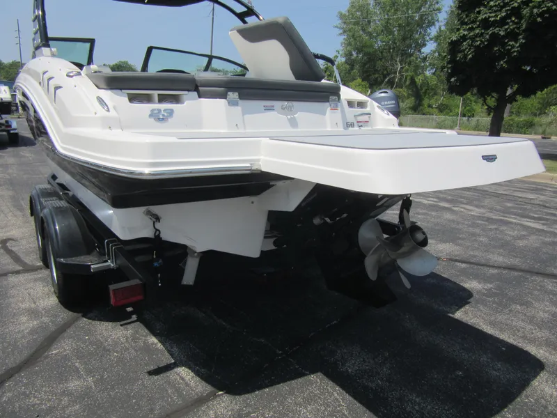 Slide: The Image of 2025 Chaparral 23 SSi boat rear view with trailer, parked on asphalt. - 5