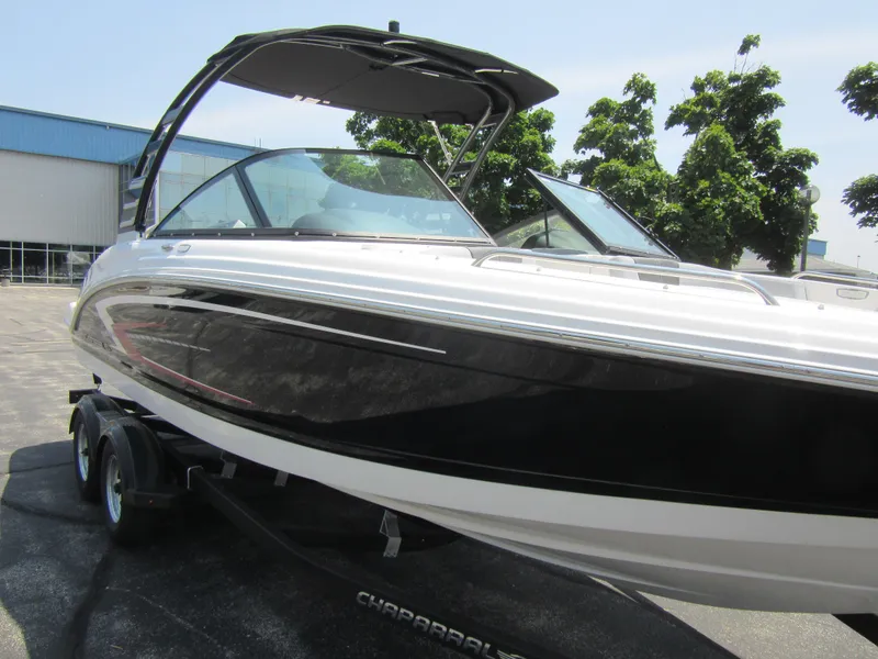 Slide: The Image of 2025 Chaparral 23 SSi boat on trailer, sleek design, black and white exterior, sunny day. - 9