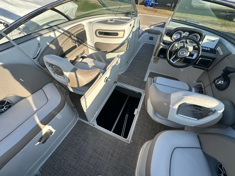 Slide: The Image of 2019 Crownline Eclipse E235 XS boat interior with open storage, steering wheel, and seating. - 18