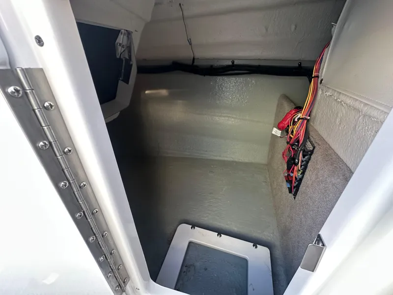 Slide: The Image of 2019 Crownline Eclipse E235 XS boat storage compartment with wiring visible. - 19