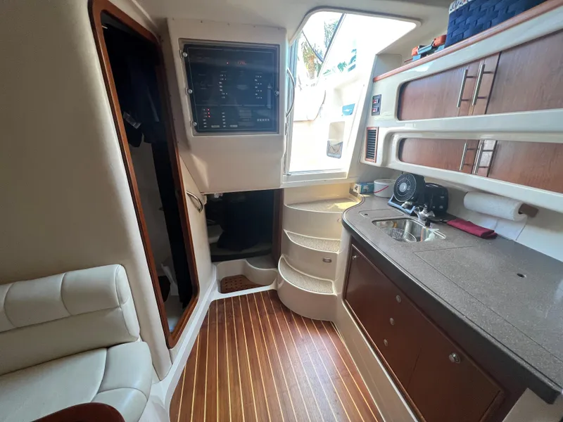 Slide: The Image of Interior of 2006 Grady-White 360 Express boat with wood flooring and compact kitchen area. - 22