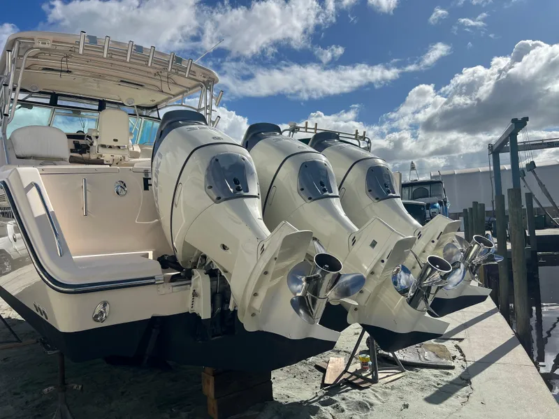 Slide: The Image of 2006 Grady-White 360 Express boat with triple outboard engines, docked under a cloudy sky. - 3
