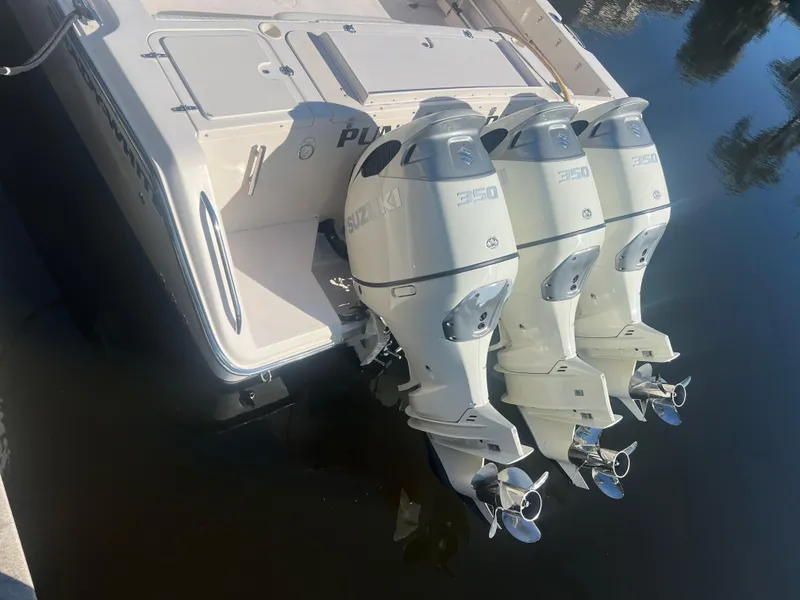 Slide: The Image of 2006 Grady-White 360 Express boat with triple outboard engines, docked on calm water. - 4