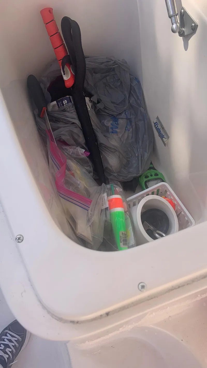 Slide: The Image of Storage compartment on a 2006 Grady-White 360 Express boat with various items inside. - 47