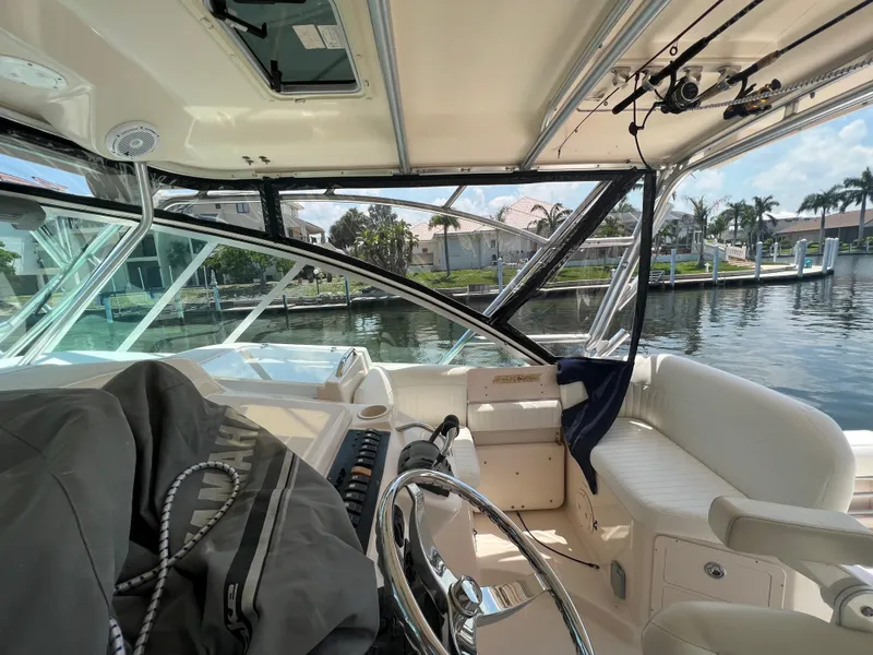 Slide: The Image of 2006 Grady-White 360 Express boat interior with steering wheel and waterfront view. - 9