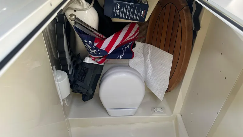 Slide: The Image of Storage compartment in 2023 Chris-Craft Catalina 24 boat with various items. - 15