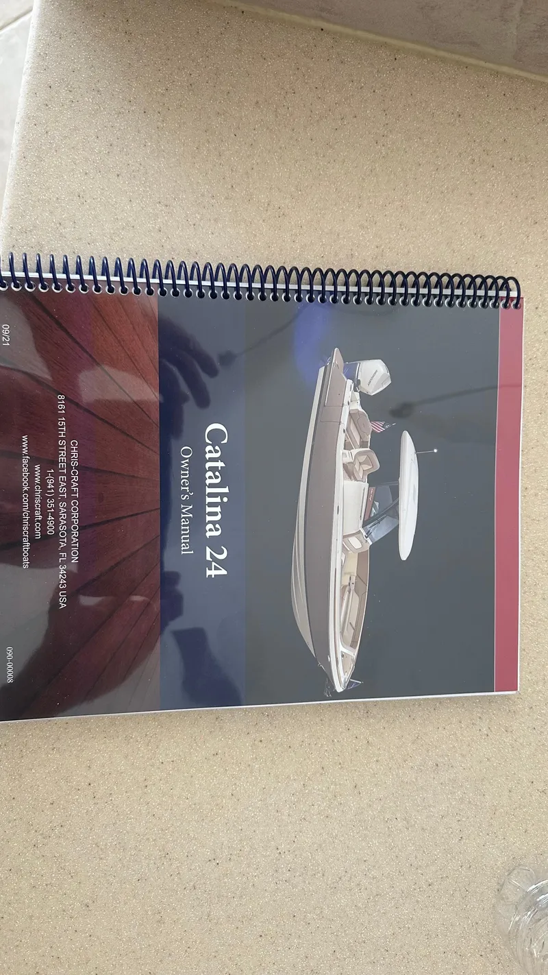Slide: The Image of 2023 Chris-Craft Catalina 24 owner's manual on a beige surface. - 18