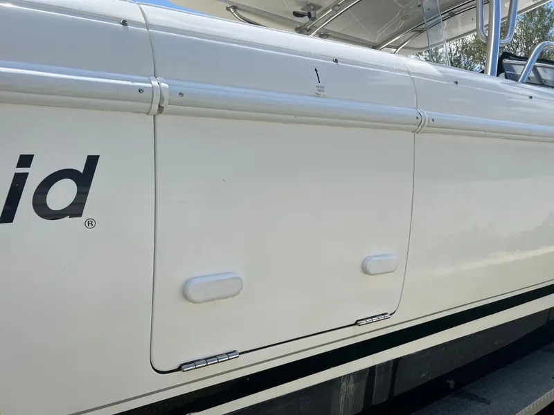 Slide: The Image of 2009 Intrepid 310 WA boat side view, showcasing sleek white exterior and branding. - 23