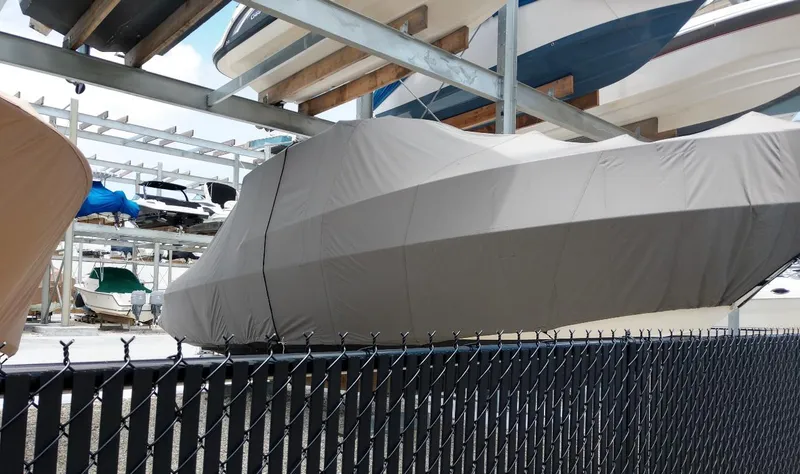 Slide: The Image of Covered 2009 Intrepid 310 WA boat in storage, behind a chain-link fence. - 34