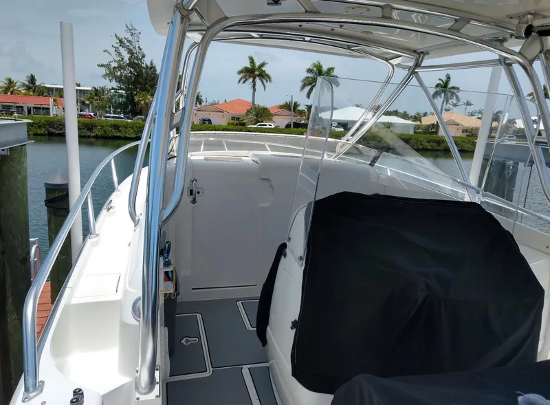 Slide: The Image of 2009 Intrepid 310 WA boat interior with sleek design, docked near palm trees. - 5