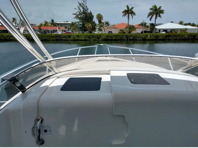 Slide: The Image of 2009 Intrepid 310 WA boat on calm water with palm trees in the background. - 6