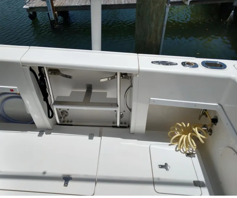 Slide: The Image of 2009 Intrepid 310 WA boat deck with storage compartments and coiled hose. - 9