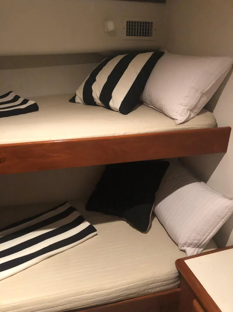 Slide: The Image of 1998 Viking 43 Convertible cabin with bunk beds and striped pillows. - 16