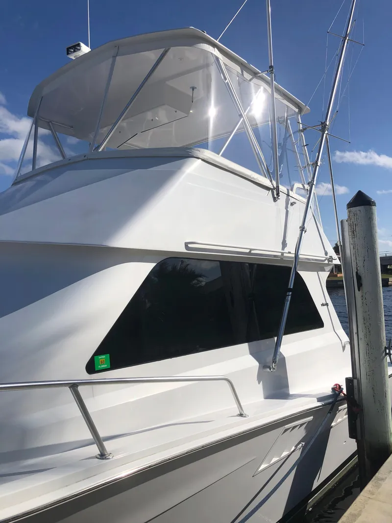 Slide: The Image of 1998 Viking 43 Convertible yacht docked under clear blue sky. - 23