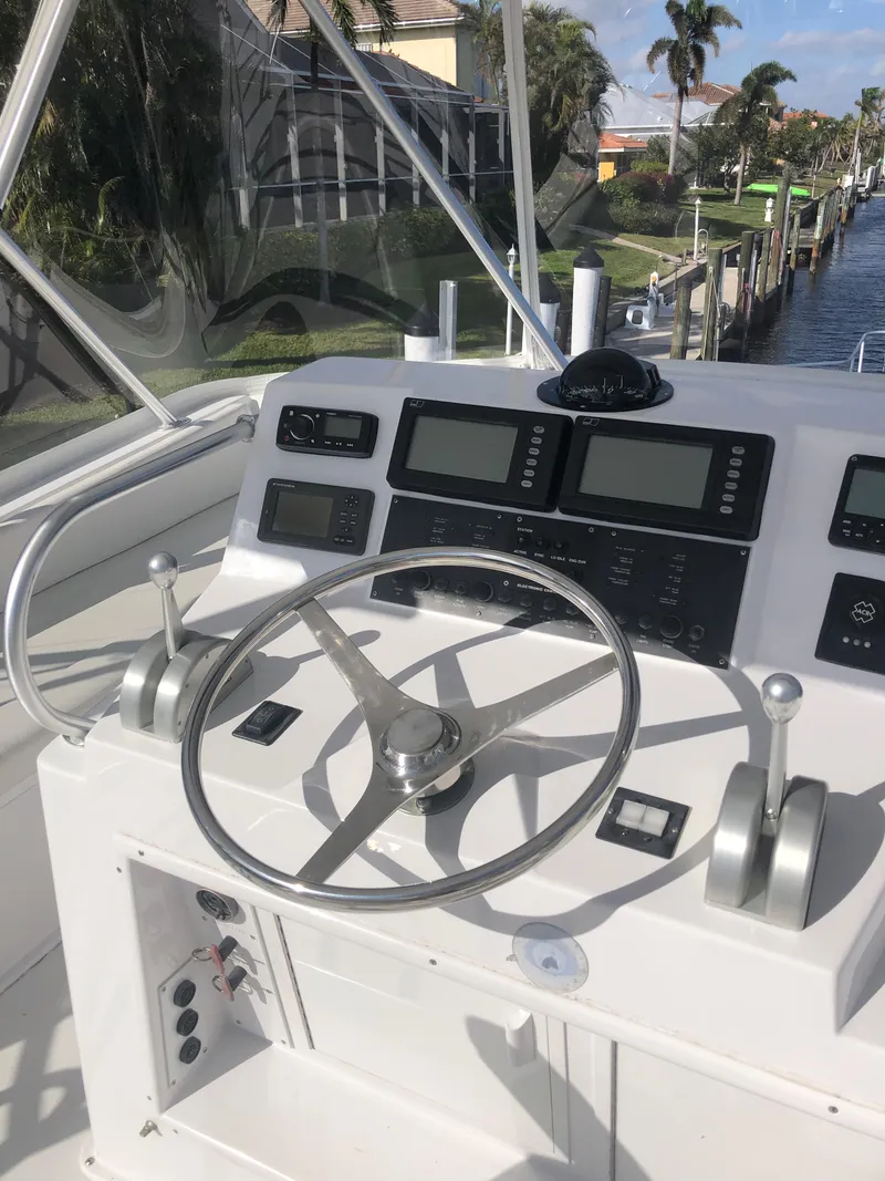 Slide: The Image of 1998 Viking 43 Convertible yacht helm with steering wheel and navigation controls. - 27
