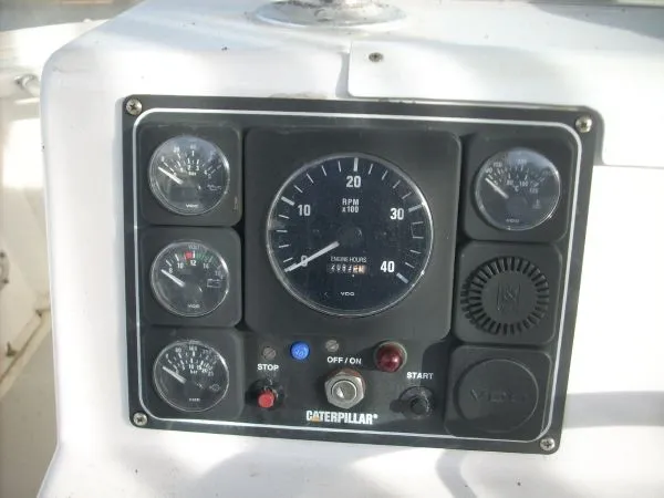 Slide: The Image of The image shows a control panel with various gauges and switches, including a tachometer. - 26