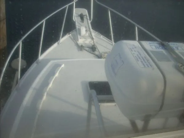 Slide: The Image of The image shows the bow of a 2000 Duffy Flybridge Sportfisherman with a life raft. - 25