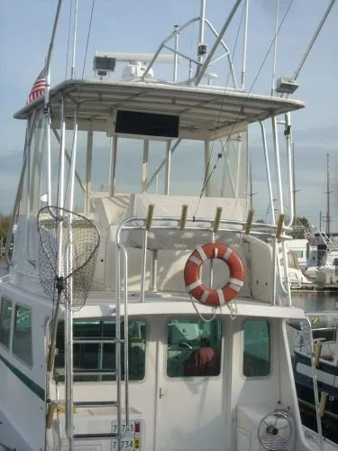 Slide: The Image of 2000 Duffy Flybridge Sportfisherman with fishing rod holders and a lifebuoy at the stern. - 39