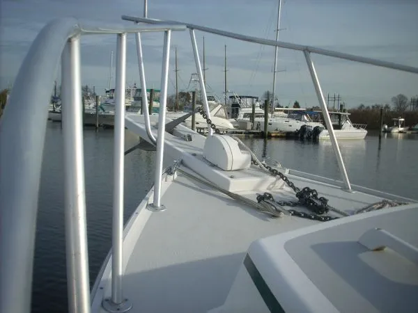 Slide: The Image of A boat with a clean deck and anchor, docked in a calm marina. - 43
