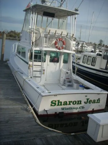 Slide: The Image of A 2000 Duffy Flybridge Sportfisherman docked. The boat features a white exterior and a flybridge. - 41
