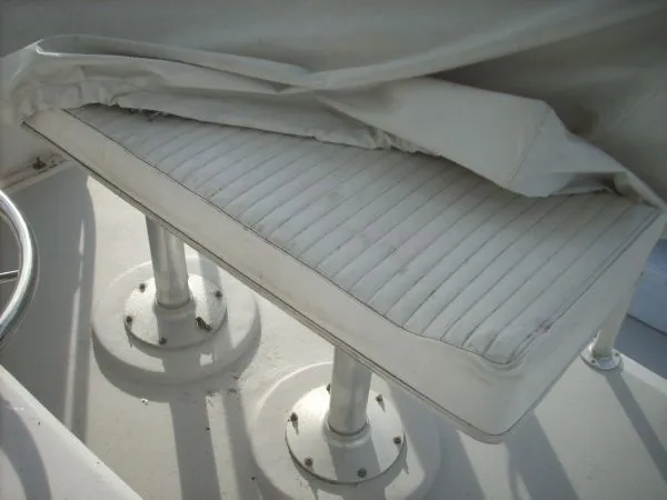 Slide: The Image of A white cushioned seat on a boat, partially covered by a tarp. - 28