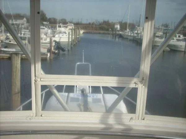 Slide: The Image of View from the flybridge of a sportfishing boat overlooking a calm marina with several boats. - 19