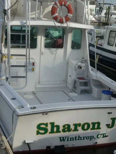 Slide: The Image of The image shows the stern of a 2000 Duffy Flybridge Sportfisherman, featuring a lifebuoy. - 40