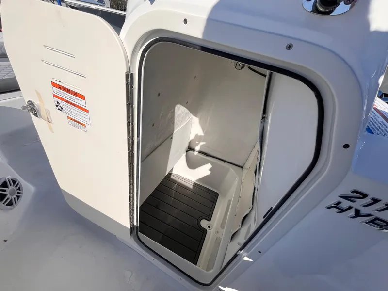 Slide: The Image of 2025 NauticStar 211 Hybrid boat storage compartment with open door. - 14