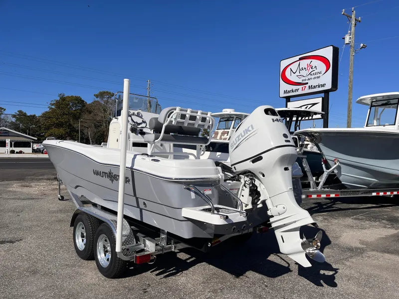 Slide: The Image of 2025 NauticStar 211 Hybrid boat on trailer at Marker 17 Marine dealership. - 2