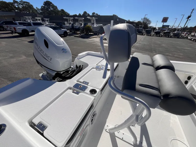 Slide: The Image of 2025 NauticStar 211 Hybrid boat with seating and motor, parked outdoors. - 5