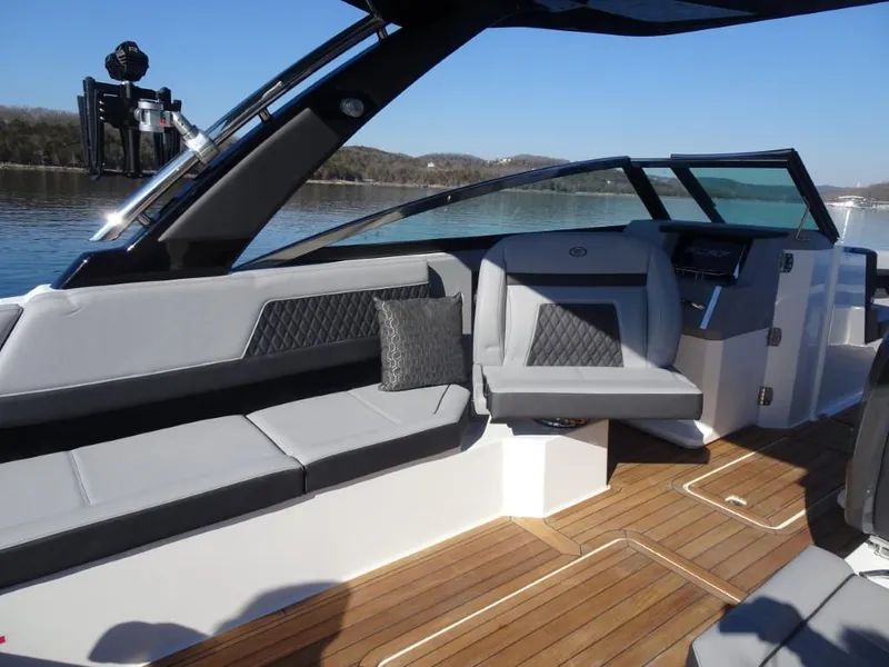 Slide: The Image of 2025 Cobalt R33 Surf boat interior with sleek seating and modern dashboard on a sunny day. - 13