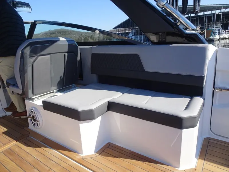 Slide: The Image of 2025 Cobalt R33 Surf boat interior with gray seating and wooden deck. - 16