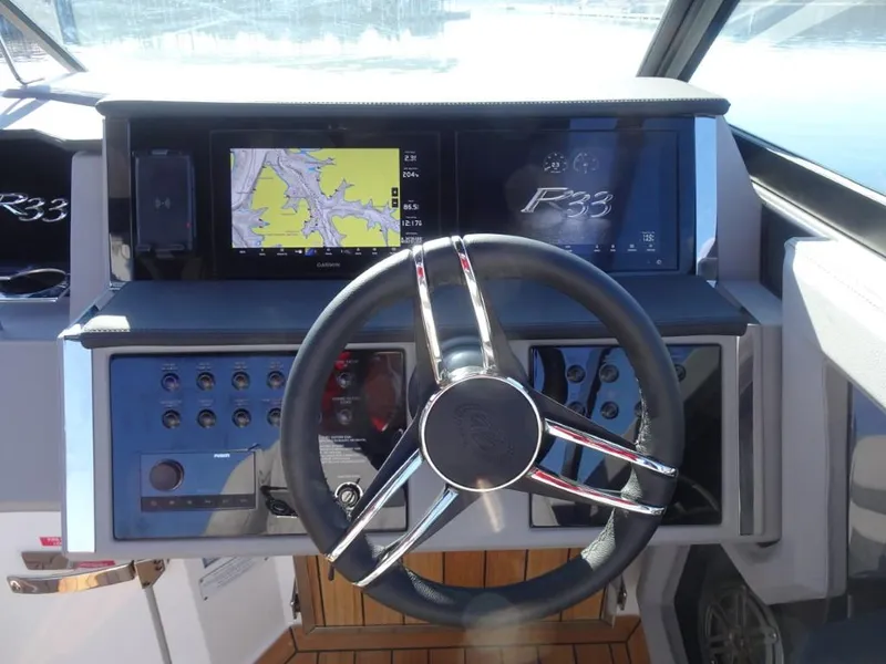 Slide: The Image of 2025 Cobalt R33 Surf boat dashboard with navigation display and steering wheel. - 21