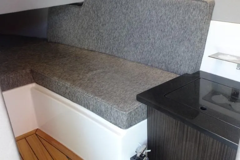 Slide: The Image of Interior of 2025 Cobalt R33 Surf boat with cushioned seating and wooden flooring. - 28