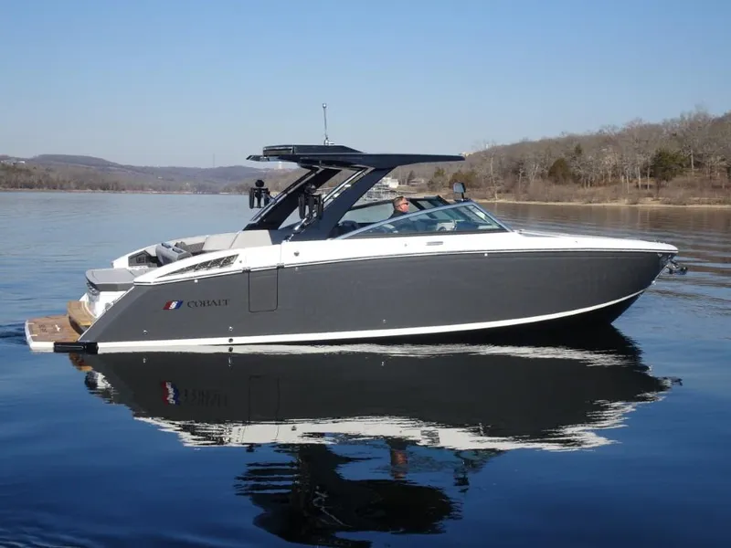 Slide: The Image of 2025 Cobalt R33 Surf boat on calm lake waters. - 3