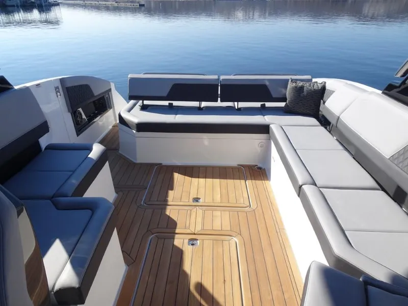 Slide: The Image of Luxurious seating on 2025 Cobalt R33 Surf boat with teak flooring, docked on calm water. - 31