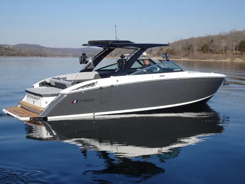 Slide: The Image of 2025 Cobalt R33 Surf boat on calm lake waters, side view. - 4