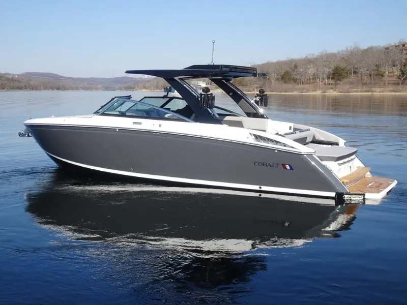 Slide: The Image of 2025 Cobalt R33 Surf boat on a calm lake with scenic background. - 6