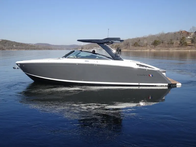 Slide: The Image of 2025 Cobalt R33 Surf boat on calm lake waters. - 7
