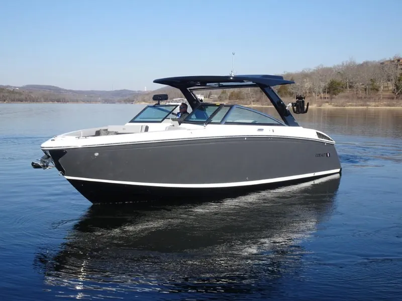 Slide: The Image of 2025 Cobalt R33 Surf boat on calm lake waters. - 9
