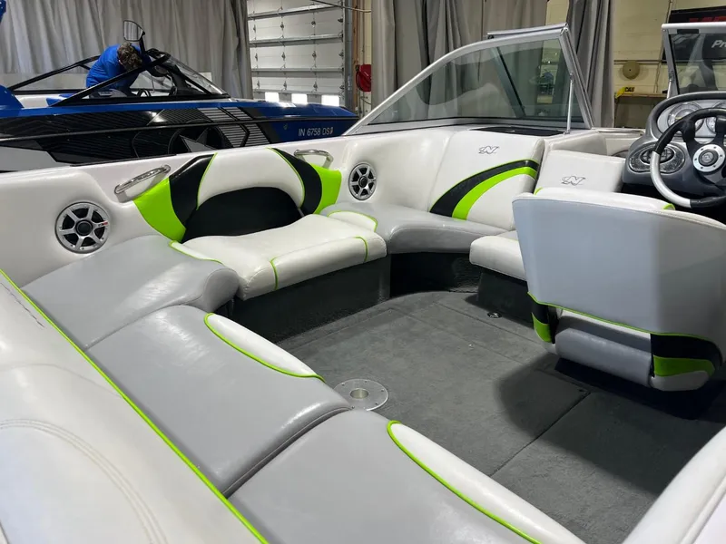 Slide: The Image of 2005 Nautique Super Air 210 boat interior with white and green seating. - 11