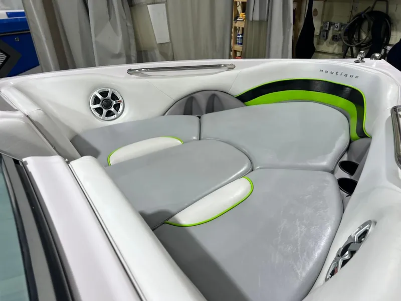 Slide: The Image of 2005 Nautique Super Air 210 boat interior with gray and green seating. - 13