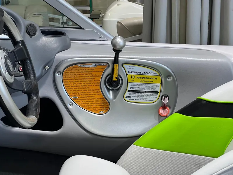 Slide: The Image of 2005 Nautique Super Air 210 interior, steering wheel, and capacity label detail. - 14